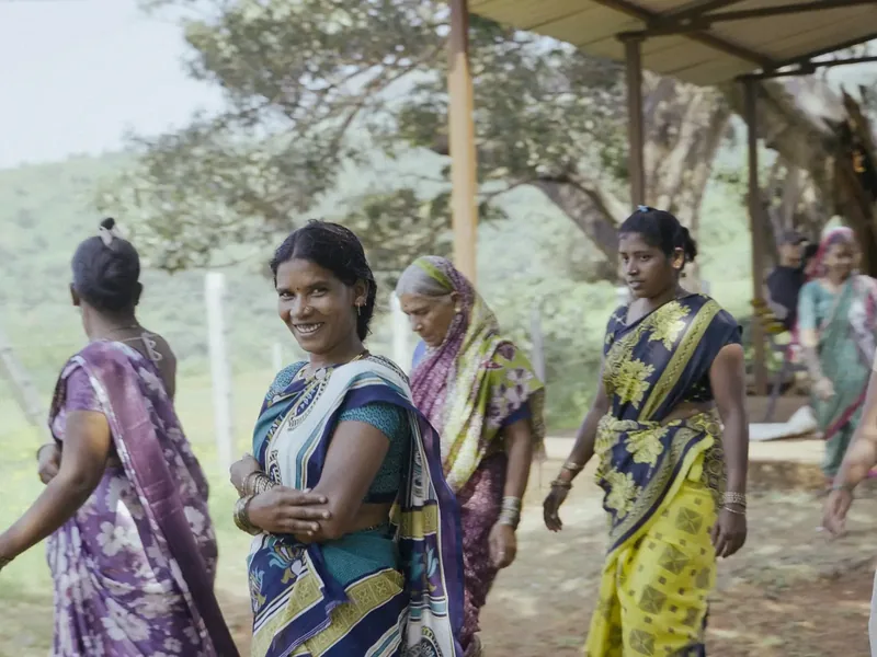 Women in colourful sarees walking together, smiling