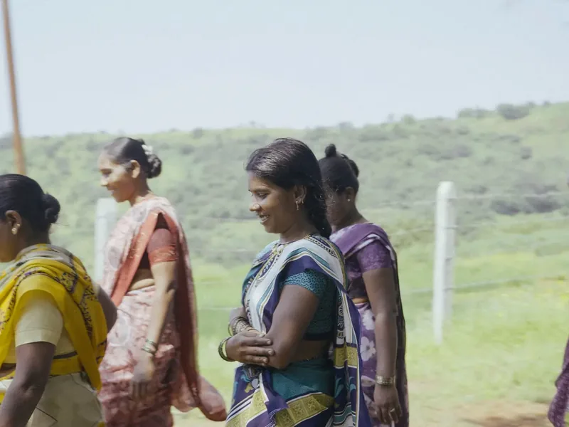 Women walking together through a village field