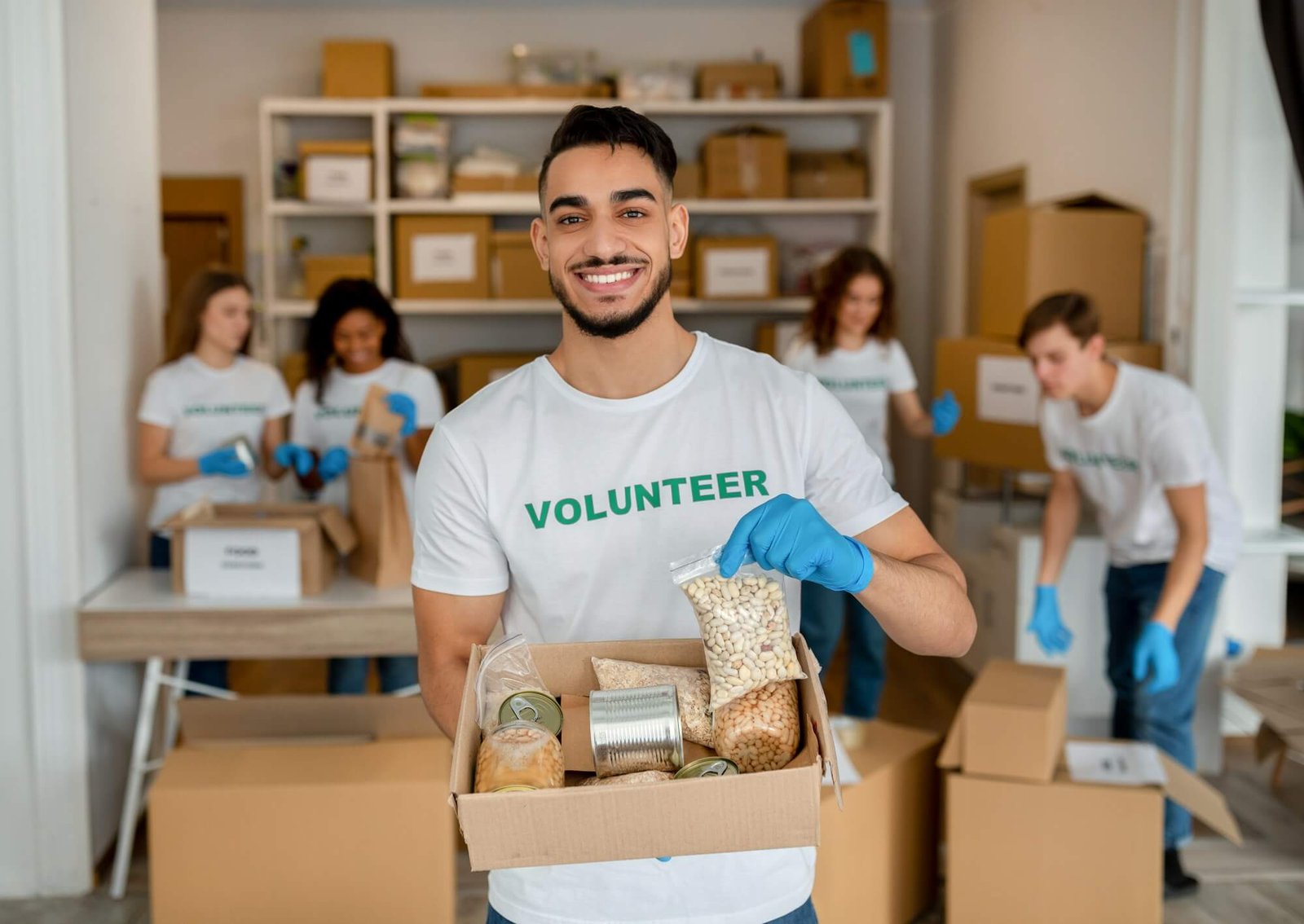 young-arab-volunteer-working-at-charity-center-holding-food-donation-box-and-smiling-to-camera.jpg
